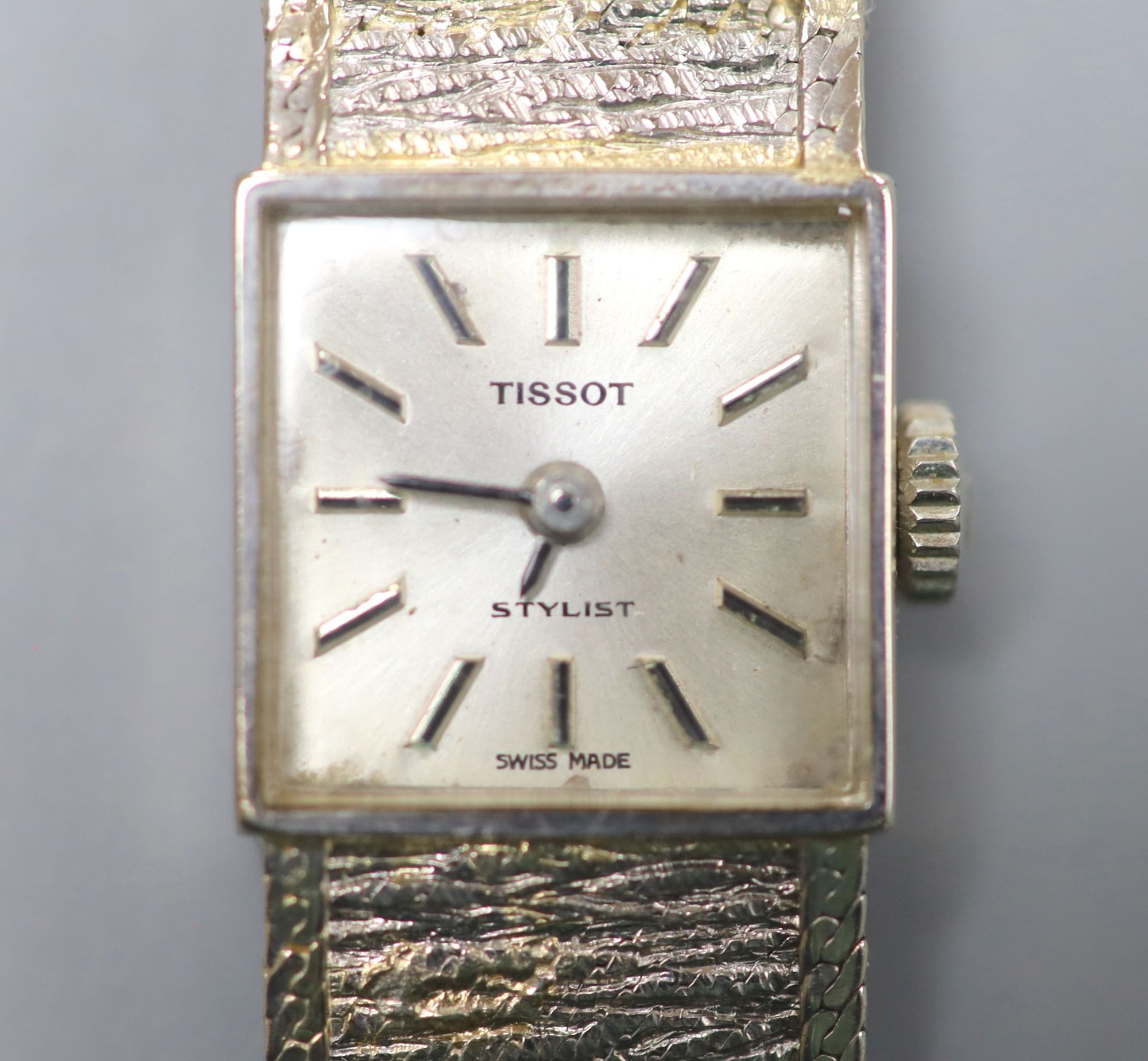 A ladys textured 9ct white gold Tissot manual wind bracelet wrist watch, overall length 17cm, gross 22 grams.